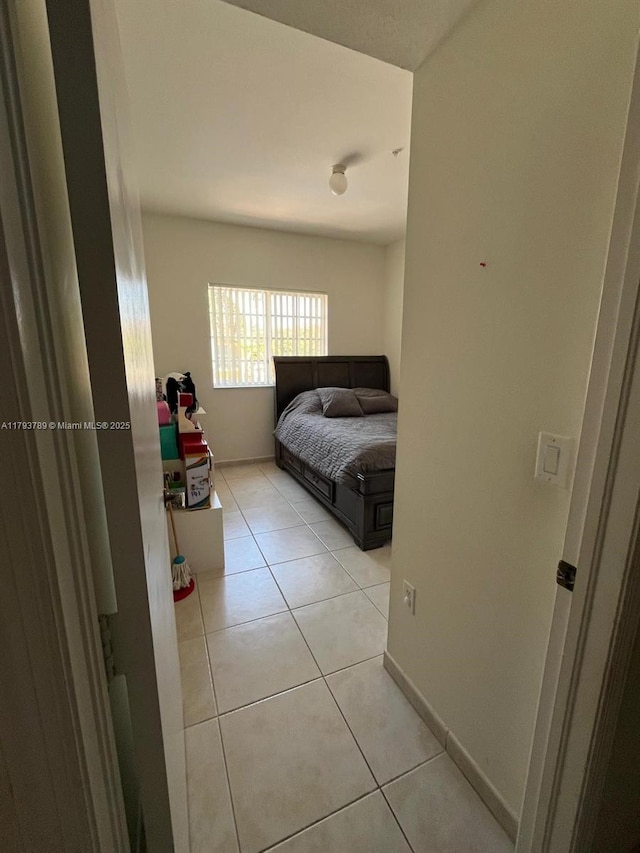 bedroom with light tile patterned floors and baseboards