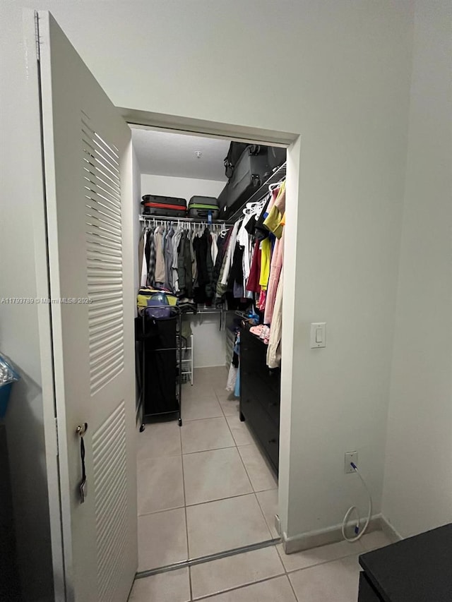 walk in closet with light tile patterned flooring