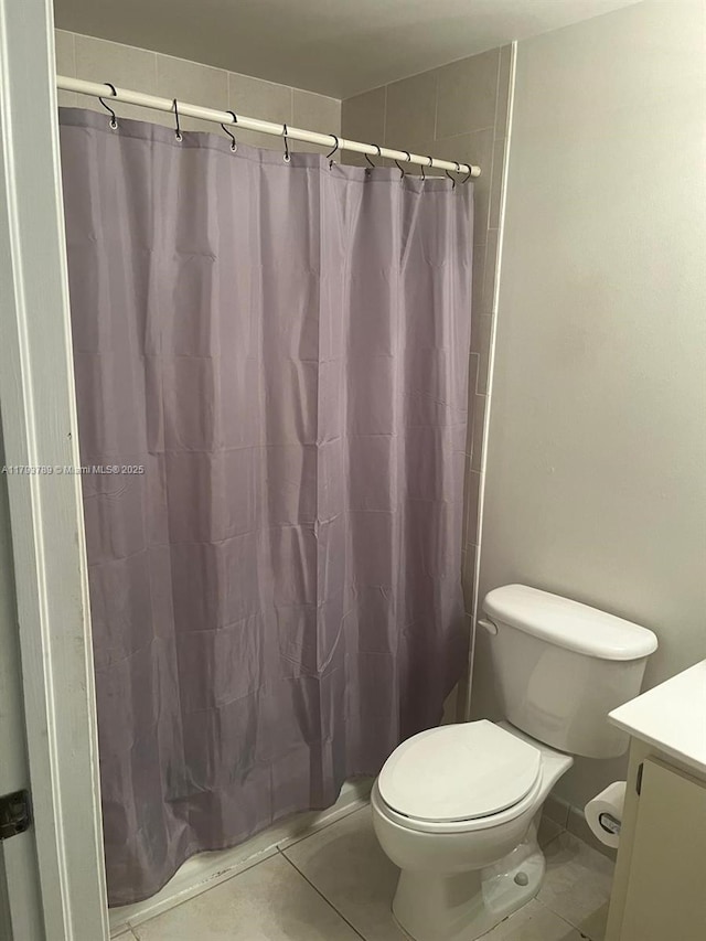 full bath featuring toilet, curtained shower, tile patterned flooring, and vanity
