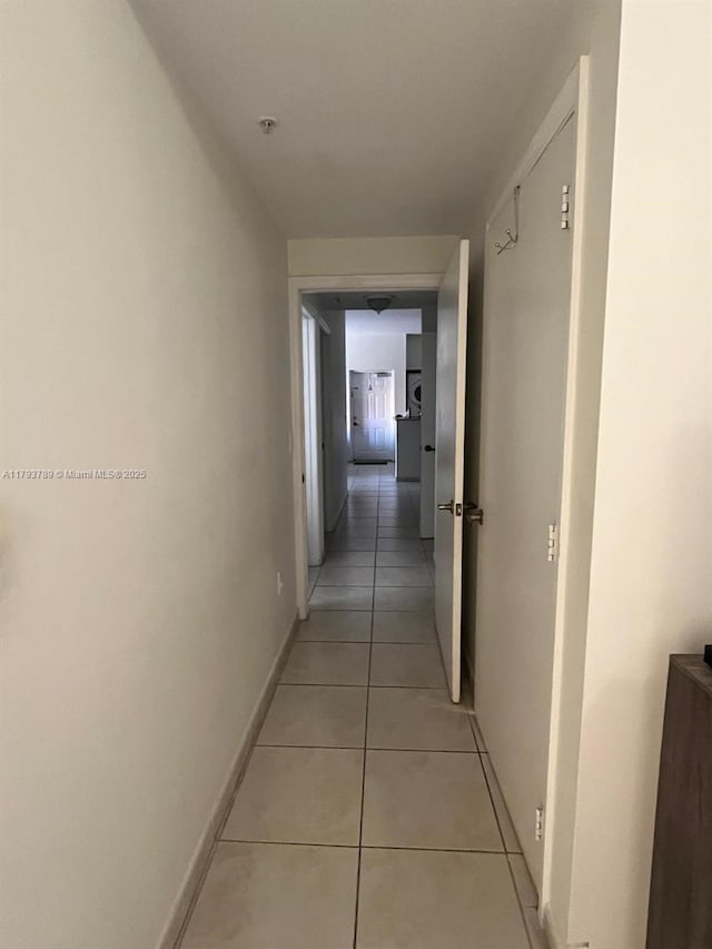 hallway featuring light tile patterned flooring and baseboards