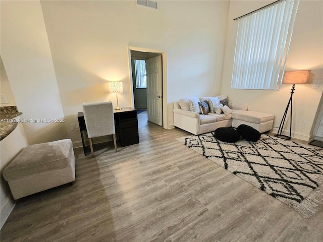 living area with visible vents, baseboards, and wood finished floors