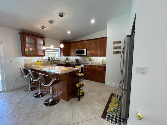 kitchen with backsplash, vaulted ceiling, light stone counters, a peninsula, and stainless steel appliances