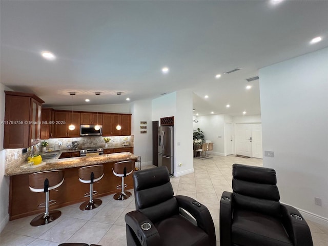 living area featuring visible vents, baseboards, light tile patterned flooring, and vaulted ceiling