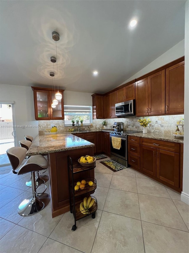 kitchen with light stone countertops, appliances with stainless steel finishes, a peninsula, lofted ceiling, and backsplash