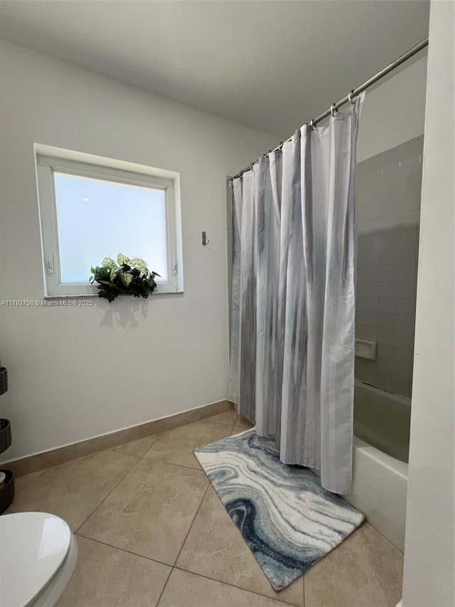 full bath featuring toilet, baseboards, shower / bath combo, and tile patterned flooring
