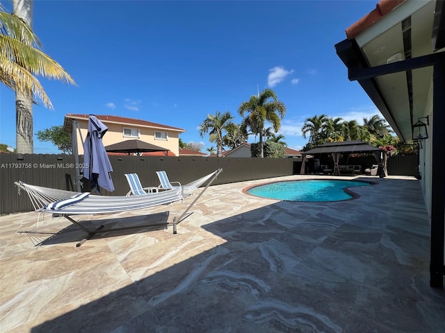 view of swimming pool with a fenced backyard, a fenced in pool, a patio, and a gazebo