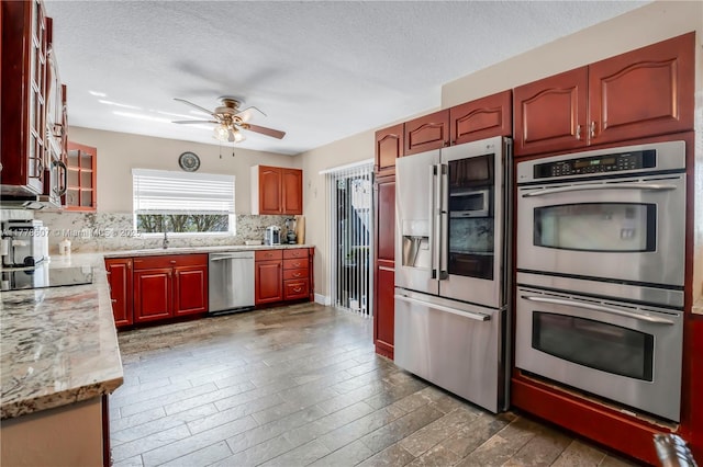 22483 Labrador St, Boca Raton, FL 33428 - kitchen featuring stainless steel appliances, backsplash, a ceiling fan, a textured ceiling, and glass insert cabinets