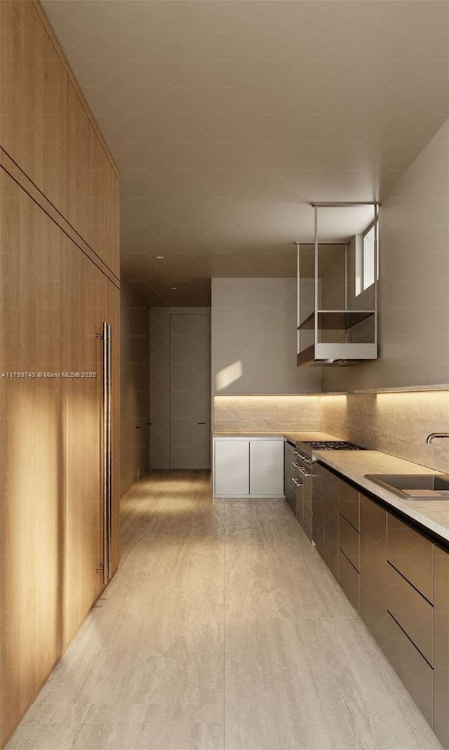 kitchen featuring light countertops, a sink, modern cabinets, and light wood-type flooring