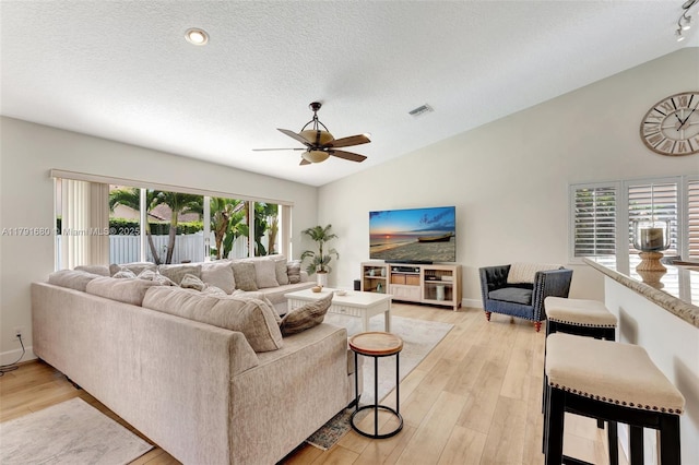 5133 N Springs Way, Coral Springs, FL 33076 - living room with a ceiling fan, a textured ceiling, visible vents, light wood finished floors, and lofted ceiling