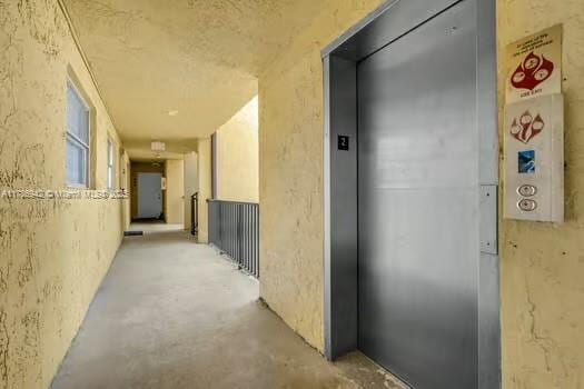 15430 SW 82nd Ln Unit 625, Miami, FL 33193 - corridor featuring elevator and unfinished concrete flooring