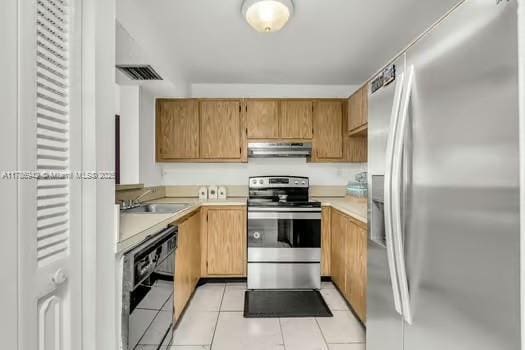 15430 SW 82nd Ln Unit 625, Miami, FL 33193 - kitchen featuring stainless steel appliances, under cabinet range hood, light tile patterned flooring, a sink, and light countertops