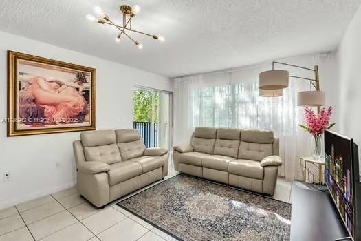 15430 SW 82nd Ln Unit 625, Miami, FL 33193 - tiled living room featuring a textured ceiling, baseboards, and a notable chandelier