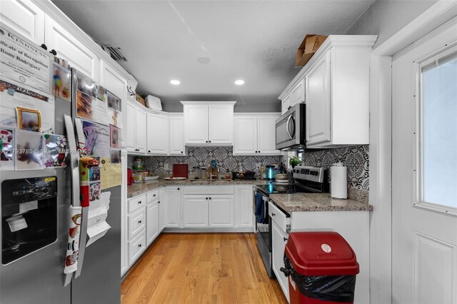 3500 SW 87th Pl, Miami, FL 33165 - kitchen with a sink, stainless steel appliances, tasteful backsplash, white cabinets, and light wood-style floors