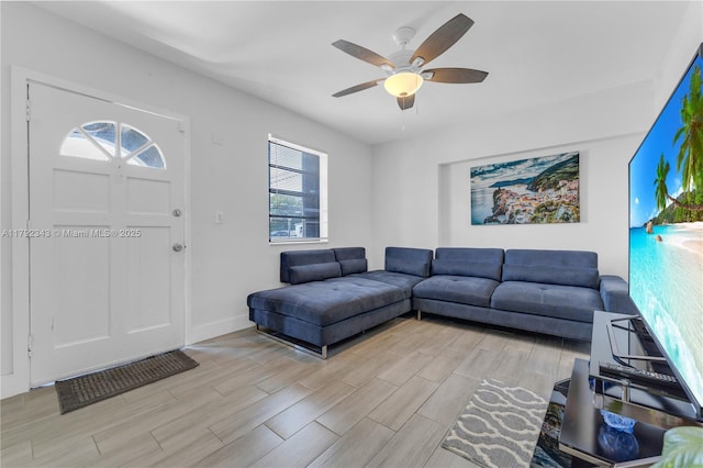 living room with baseboards, ceiling fan, and wood finish floors