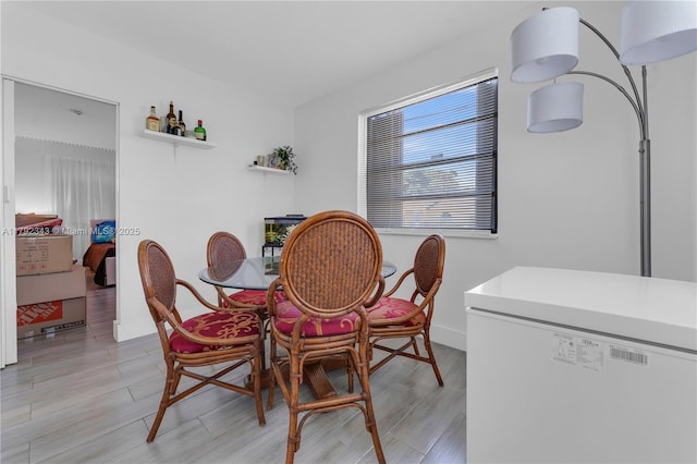 dining room with baseboards and light wood-style flooring