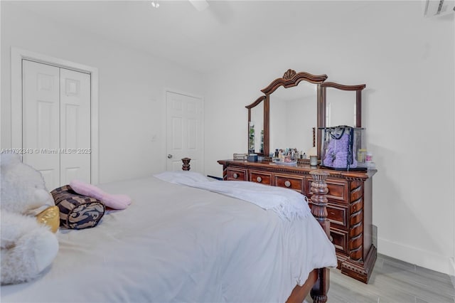 bedroom featuring light wood finished floors, a ceiling fan, baseboards, visible vents, and a closet