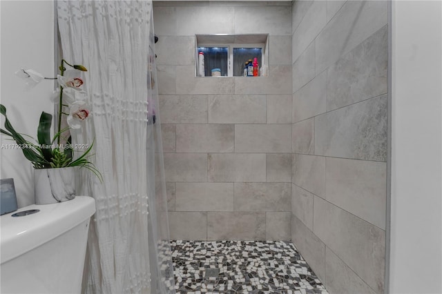 bathroom featuring toilet and tiled shower