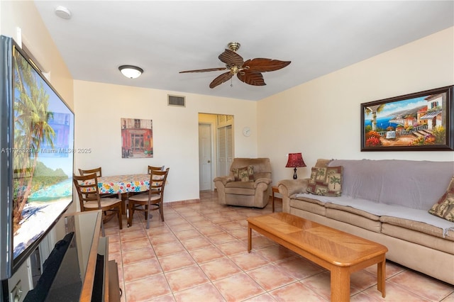 living room featuring a ceiling fan, baseboards, visible vents, and light tile patterned floors