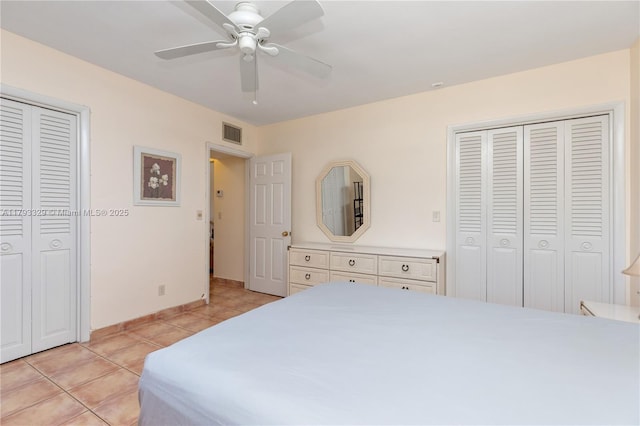 bedroom with visible vents, a ceiling fan, baseboards, and light tile patterned floors