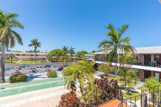 view of property's community featuring fence and shuffleboard