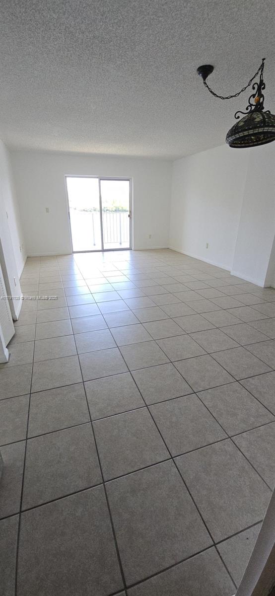 8240 SW 210th St Unit 214, Cutler Bay, FL 33189 - dining space with baseboards, a textured ceiling, and light tile patterned flooring
