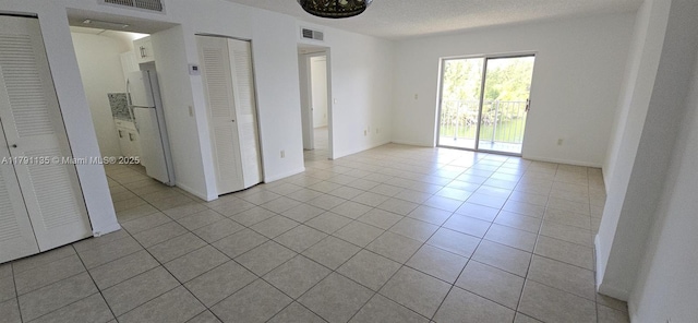 8240 SW 210th St Unit 214, Cutler Bay, FL 33189 - unfurnished bedroom featuring freestanding refrigerator, tile patterned floors, access to exterior, and two closets
