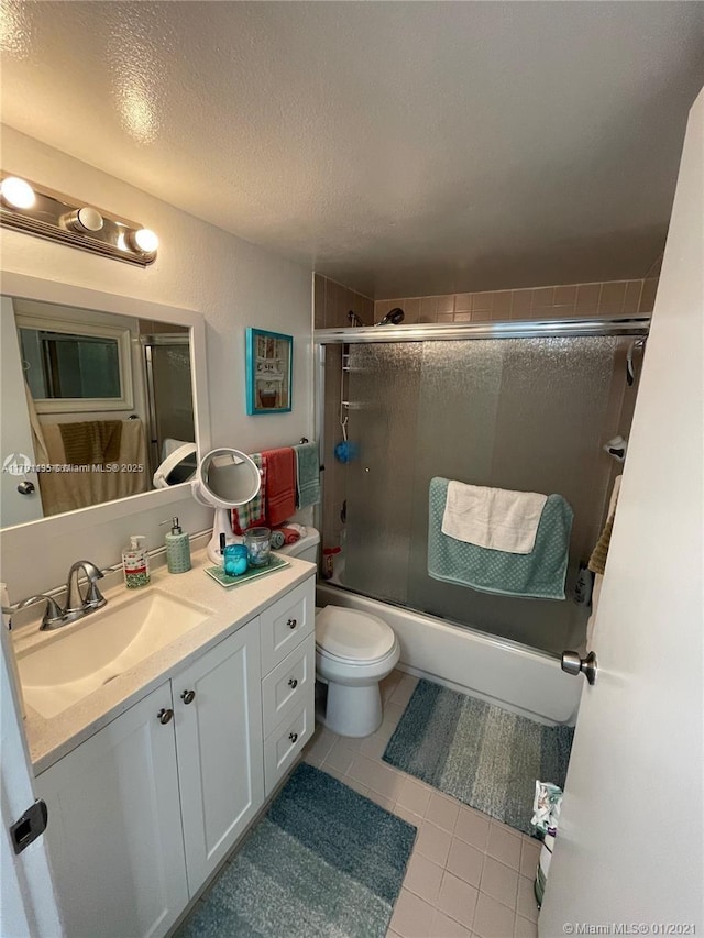 8240 SW 210th St Unit 214, Cutler Bay, FL 33189 - full bath featuring a textured ceiling, tile patterned flooring, vanity, toilet, and enclosed tub / shower combo
