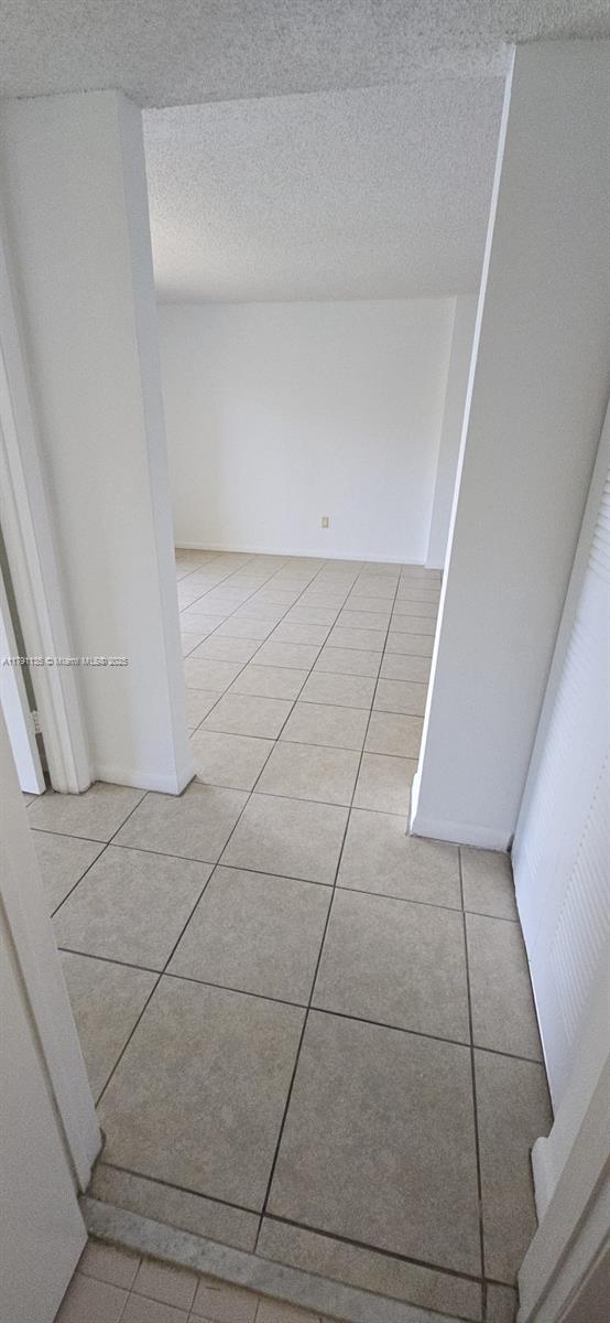 8240 SW 210th St Unit 214, Cutler Bay, FL 33189 - corridor featuring light tile patterned floors and a textured ceiling