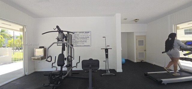 8240 SW 210th St Unit 214, Cutler Bay, FL 33189 - exercise area featuring healthy amount of natural light, a textured ceiling, and baseboards