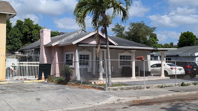 248 SW 18th Ct, Miami, FL 33135 - bungalow-style home featuring stucco siding, a chimney, and a fenced front yard