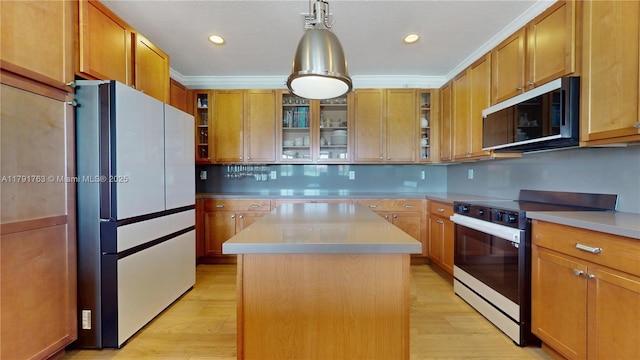 kitchen featuring freestanding refrigerator, electric range, a center island, light countertops, and light wood-style flooring