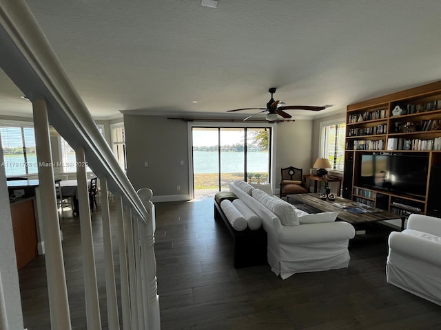 living area featuring baseboards, a ceiling fan, and dark wood-style flooring