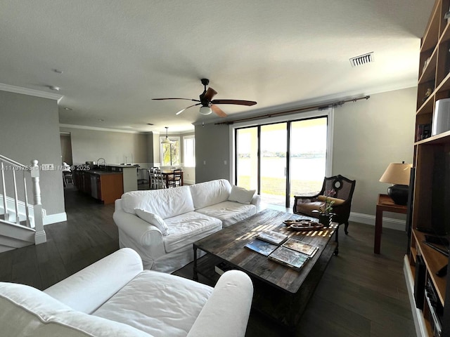 living room featuring a ceiling fan, baseboards, visible vents, and ornamental molding