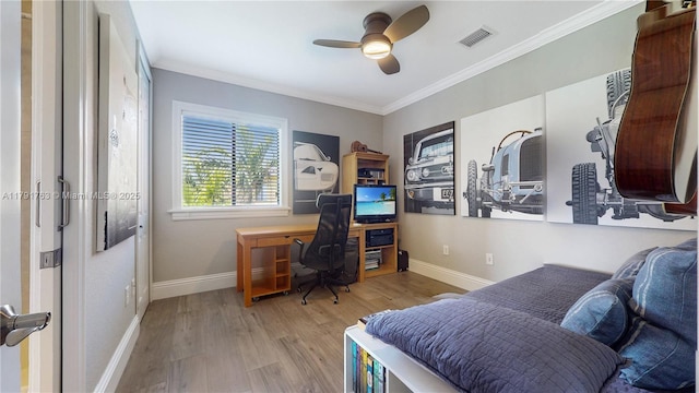 office featuring ceiling fan, visible vents, wood finished floors, baseboards, and ornamental molding