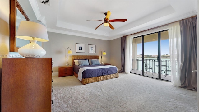 bedroom featuring visible vents, access to outside, a raised ceiling, a water view, and carpet flooring