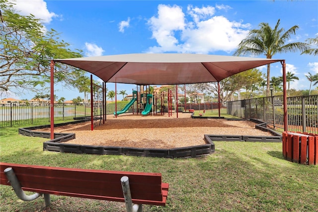community play area featuring a lawn and fence