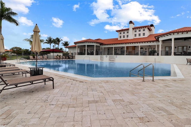 community pool featuring a patio, fence, and a ceiling fan