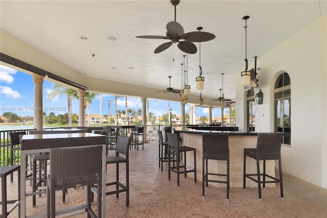 view of patio / terrace featuring a water view, ceiling fan, and outdoor dry bar