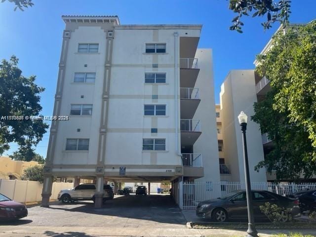 view of property featuring covered parking and fence