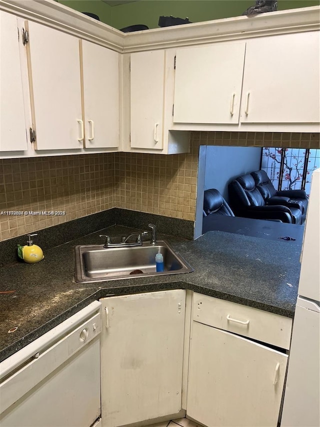 kitchen featuring a sink, backsplash, white appliances, and white cabinetry