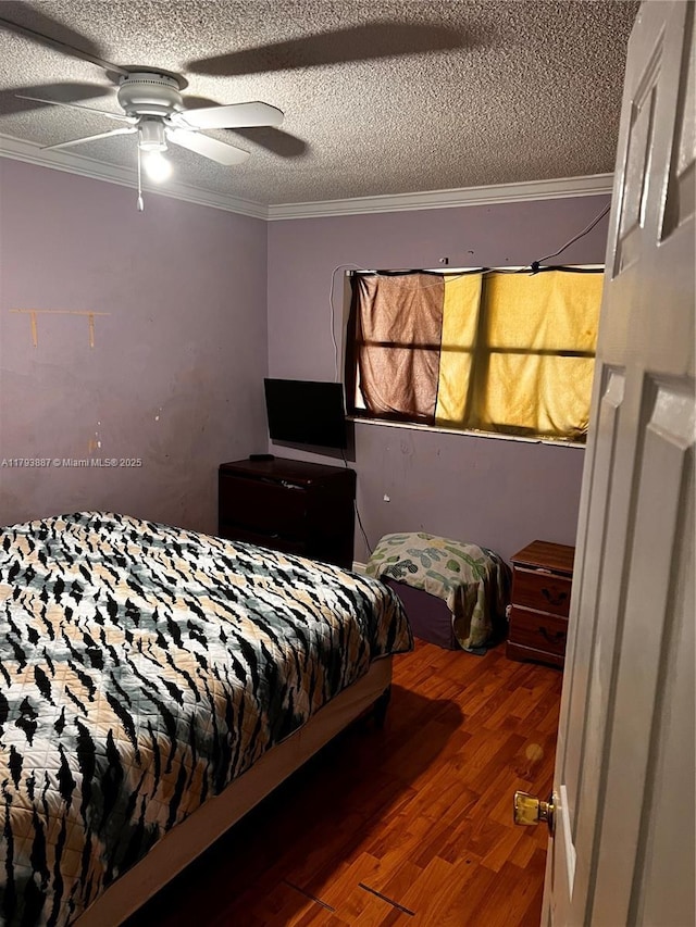 bedroom with a textured ceiling, ornamental molding, a ceiling fan, and wood finished floors