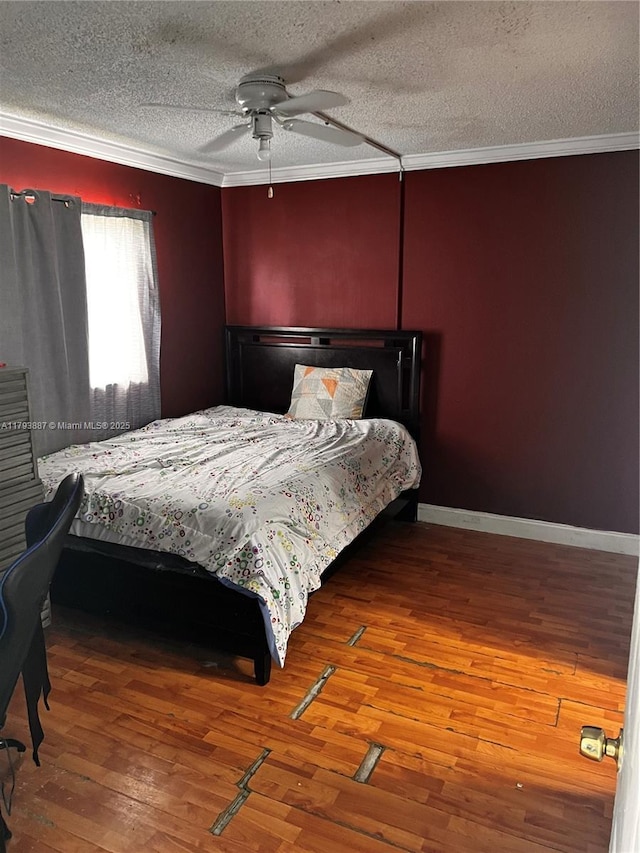 bedroom featuring a textured ceiling, a ceiling fan, baseboards, ornamental molding, and hardwood / wood-style flooring