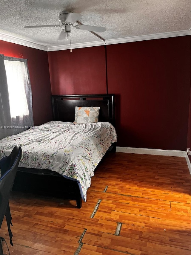 bedroom with crown molding, a textured ceiling, and wood finished floors