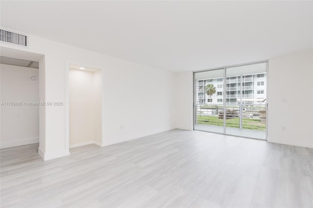 3600 NE 170th St Unit D-112, North Miami Beach, FL 33160 - spare room featuring visible vents, floor to ceiling windows, and wood finished floors