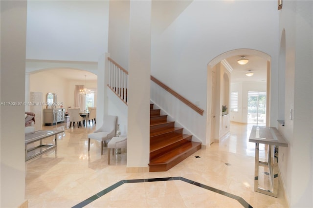 15852 SW 15th St, Davie, FL 33326 - foyer entrance with a towering ceiling, baseboards, stairway, a chandelier, and arched walkways