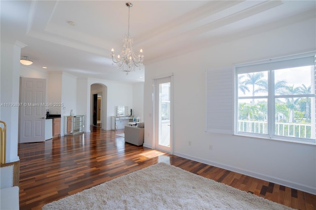 15852 SW 15th St, Davie, FL 33326 - empty room featuring wood finished floors, baseboards, a raised ceiling, a chandelier, and arched walkways