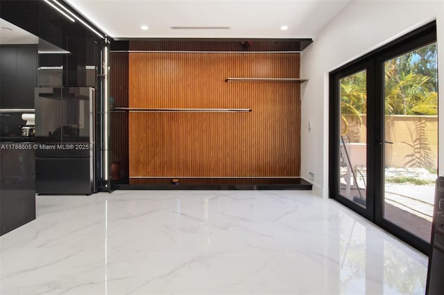 interior space featuring recessed lighting, marble finish floor, and wooden walls