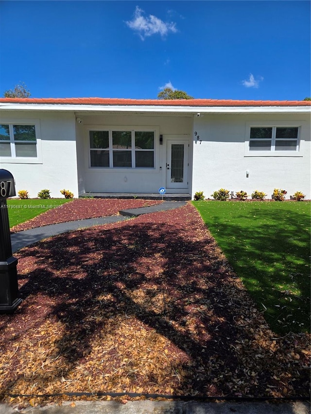 single story home featuring a front yard and stucco siding