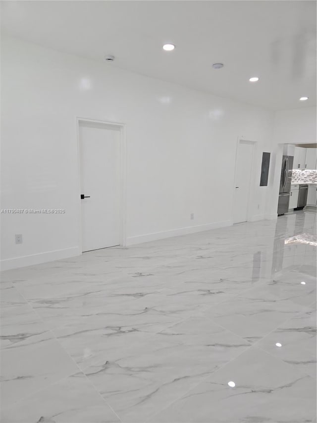 spare room featuring recessed lighting, baseboards, and marble finish floor