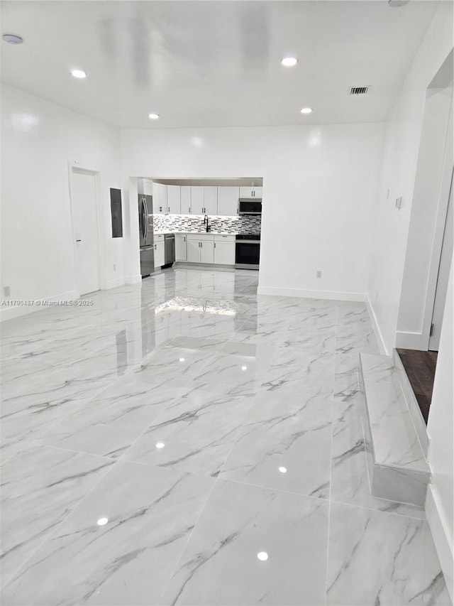 empty room with baseboards, marble finish floor, recessed lighting, and visible vents